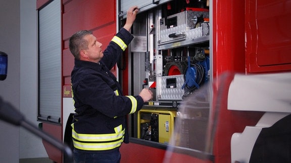 Frank Ochsner ist Bürgermeister und Feuerwehrgerätewart. Er kontrolliert das Equitment eines Feuerwehrautos.