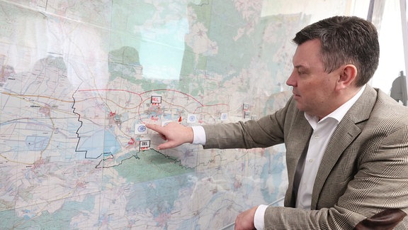Andre Schröder, (CDU), Landrat des Landkreises Mansfeld-Südharz, erläutert im Katastrophenstab an einer Karte die Verteilung der Einsatzkräfte. 