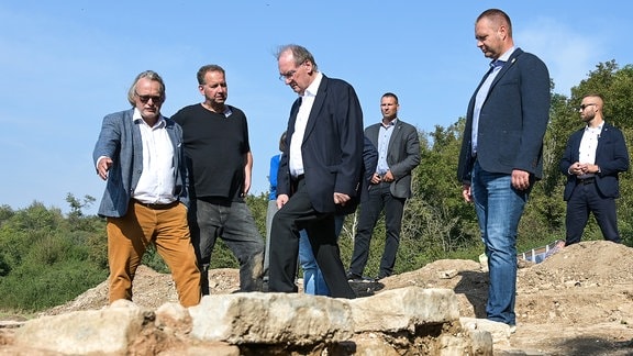 Rainer Haseloff (CDU, 3.v.l), Ministerpräsident von Sachsen-Anhalt, und Harald Meller (l), Landesarchäologe von Sachsen-Anhalt, besichtigen eine Ausgrabungsstätte.