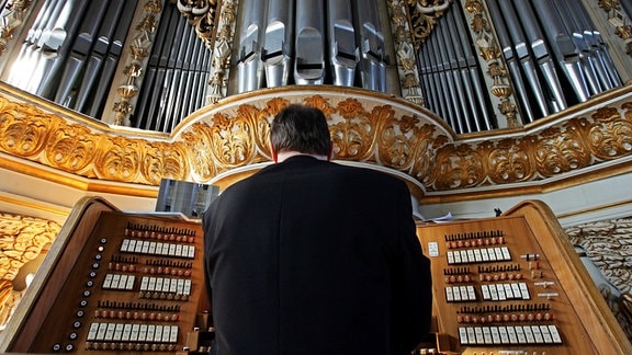 Ein Organist spielt während eines Gottesdienstes an der historischen Orgel in die Marktkirche in Halle (Saale)