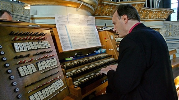 Ein Organist spielt während eines Gottesdienstes an der historischen Orgel in die Marktkirche in Halle (Saale)