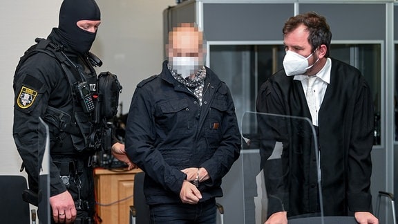 Der Angeklagte Stephan B. (M) wird von Justizpersonal in den Saal des Landgerichts begleitet und nimmt neben seinem Verteidiger Thomas Rutkowski (r) Platz. 