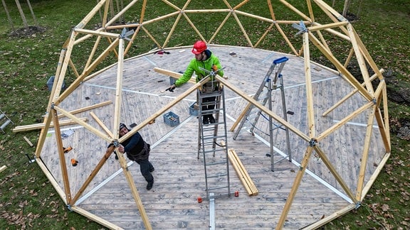 Arbeiter errichten eine geodätische Kuppel, einen so genannten Buckminster Fuller Dome, auf dem Gelände der Landesgartenschau (Aufnahme mit Drohne). 