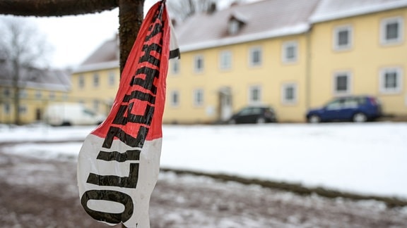 Absperrband der Polizei ist vor einem Wohnhaus zu sehen.