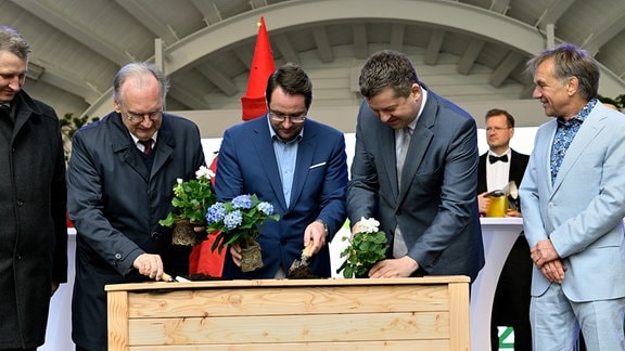 Ministerpräsident Reiner Haseloff, Bürgermeister Christoph Schulze und Wirtschaftsminister Sven Schulze pflanzen Blumen zur Eröffnung der Landesgartenschau 2024