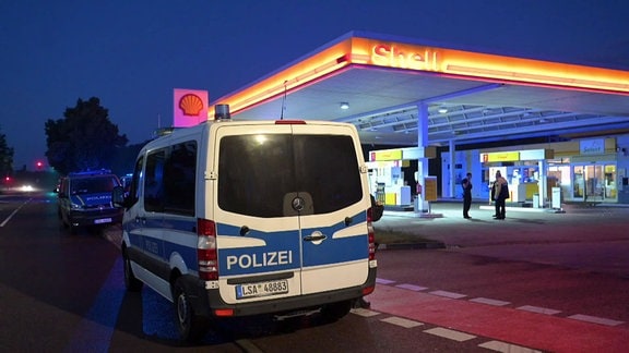 Polizeiwagen an einer Tankstelle.
