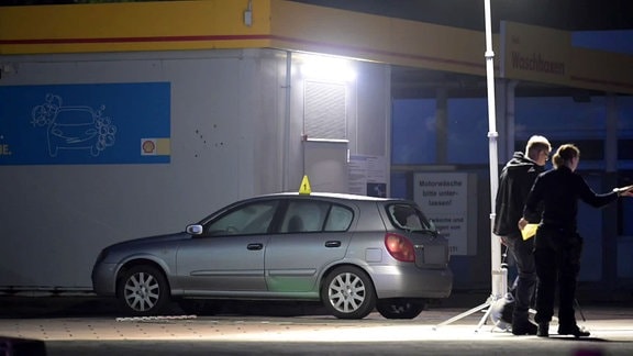 Kriminaltechnische Untersuchung eines Autos an einer Tankstelle.
