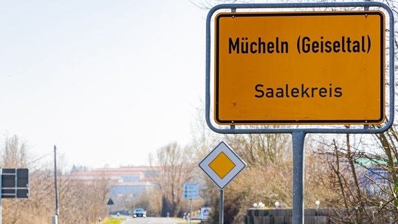 Das Ortseingangsschild von Mücheln im Geiseltal steht neben einer Straße.