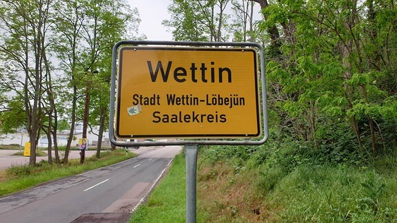 Ein gelbes Ortseingangsschild mit der Aufschrift "Wettin".