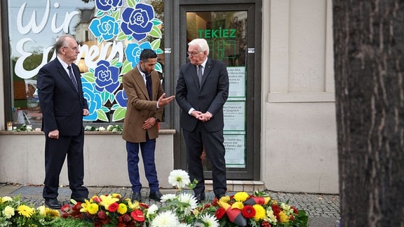 Bundespräsident Frank-Walter Steinmeier (r-l), Ismet Tekin, Inhaber des Dönerladens «Kiez Döner» und Reiner Haseloff, Ministerpräsident von Sachsen-Anhalt, legen vor dem Dönerladen einen Kranz für die Opfer des Terroranschlags von 2019 nieder. 