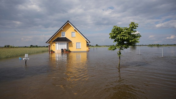 Ein Einfamilienhaus steht am 11.06.2013 im Hochwasser am Dorfrand von Schönhausen (Sachsen-Anhalt).