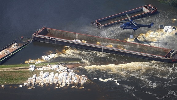 Ein Hubschrauber wirft am 17.06.2013 so genannte BigPacks an den Dammbruch in Fischbeck (Sachsen-Anhalt).