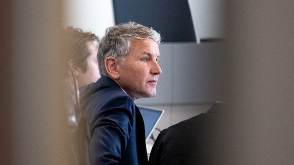 Björn Höcke, Vorsitzender der Thüringer AfD, ist in einer Verhandlungspause durch die geöffnete Tür des Gerichtssaals im Landgericht zu sehen.