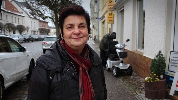 Eine Frau schaut in die Kamera. Sie steht in einer Straße in Jessen.