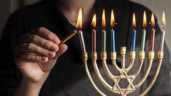 Kerzen an einem jüdischen Kerzenleuchter werden angezündet