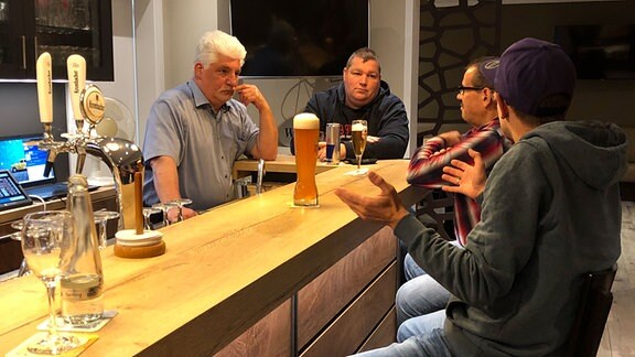Männer sitzen in einer Bar.