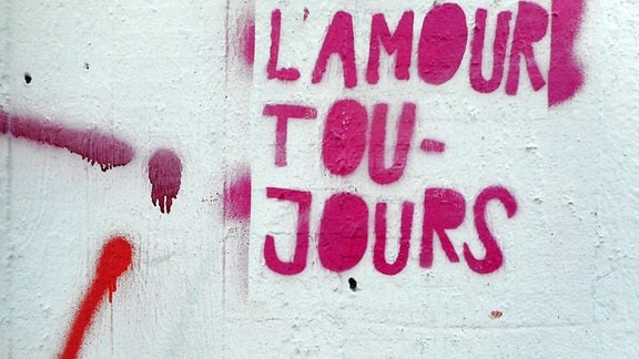 L' Amour Toujours steht an einer Hauswand