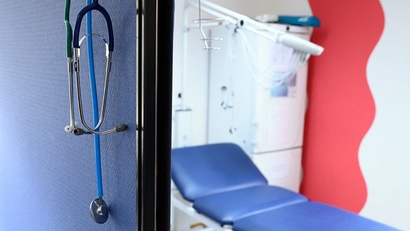 Stethoskope hängen 2021 im Behandlungszimmer einer Hausarztpraxis über einer Trennwand.