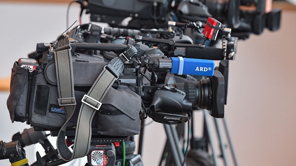 Mehrere Kameras von verschiedenen Fernsehsendern, darunter auch der ARD, stehen nebeneinander auf einer Pressekonferenz