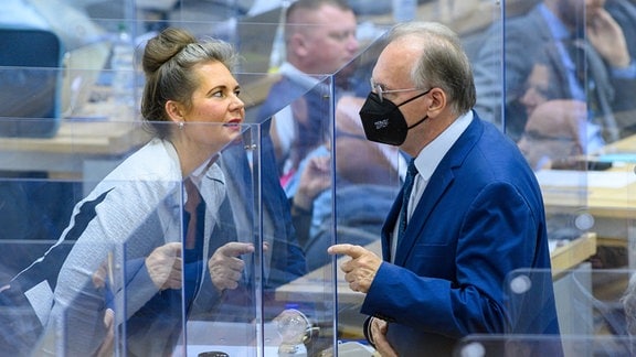 Reiner Haseloff (r, CDU), Ministerpräsident des Landes Sachsen-Anhalt spricht im Penarsaal des Landtages mit der CDU-Abgeordneten Elke Simon-Kuch.