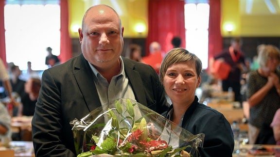 Hendrik Lange vom Stadtverband Halle bekommt von Janina Böttger (Landesvorsitzende Die Linke Sachsen-Anhalt) Blumen