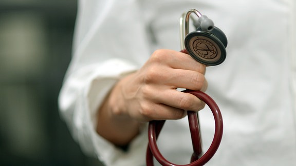 Ein Medizinstudent hält ein Stethoskop in der Hand.