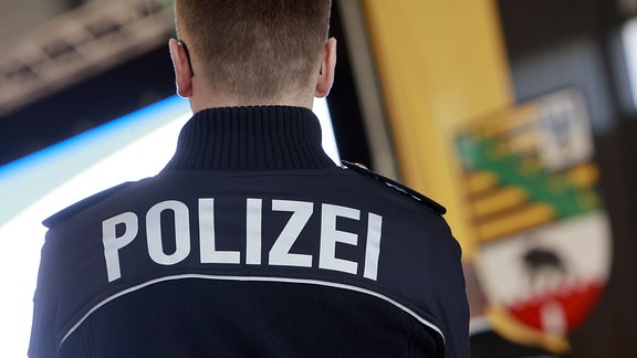Ein Polizeibeamter steht während der Zeugnisausgabe für Absolventinnen und Absolventen der Fachhochschule Polizei im Ballhaus Aschersleben. 