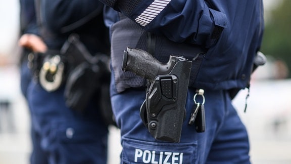 Polizisten tragen Dienstwaffe und Handschellen 