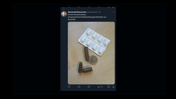 Screenshot des Tweets von Alexander Räuscher. Auf dem Foto sind drei Patronen, eine Euro-Münze und eine Packung Tabletten zu sehen.