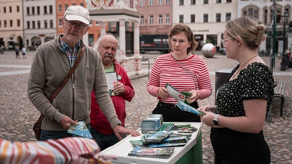 Zwei Männer und zwei Frauen stehen an einem Wahlkampfstand der Grünen.