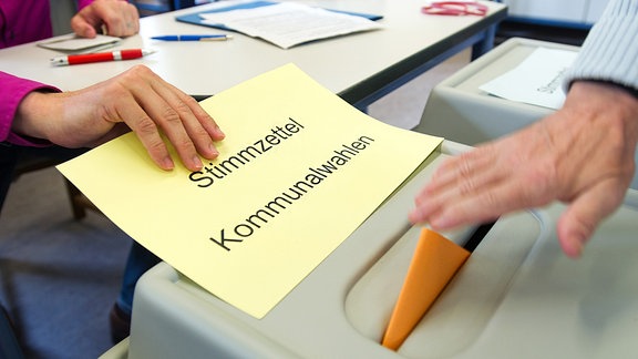 Ein Wähler wirft seine Stimmzettel in die Urne für die Kommunalwahl.