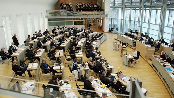 Abgeordnete sitzen im Sitzungssaal des Landtags.