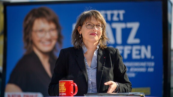 Katja Pähle (SPD), Spitzenkandidatin der SPD bei den Landtagswahlen in Sachsen-Anhalt, steht vor einem Wahlplakat der Partei