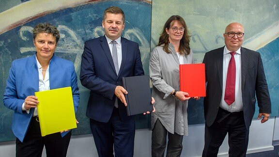 Lydia Hüskens (l-r), Vorsitzende der FDP in Sachsen-Anhalt, Sven Schulze, Vorsitzender der CDU in Sachsen-Anhalt, Juliane Kleemann und Andreas Schmidt, beide Vorsitzende der SPD in Sachsen-Anhalt, zeigen den unterschriebenen Koalitionsvertrag.