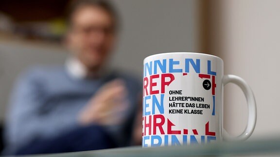 Magdeburgs Uni-Rektor Jens Strackeljan spricht während eines dpa-Interviews in seinem Büro auf dem Campus der Otto-von-Guericke-Universität Magdeburg hinter einer Tasse mit der Aufschrift «Ohne Lehrer*innen hätte das Leben keine Klasse».