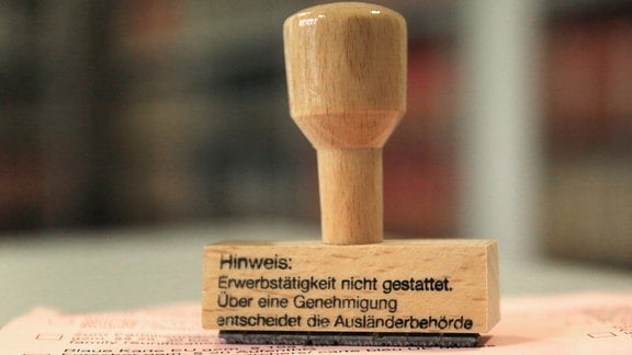 Ein Stempel mit der Aufschrift "Hinweis: Erwerbstätigkeit nicht gestattet. Über eine Genehmigung entscheidet die Ausländerbehörde", 2015