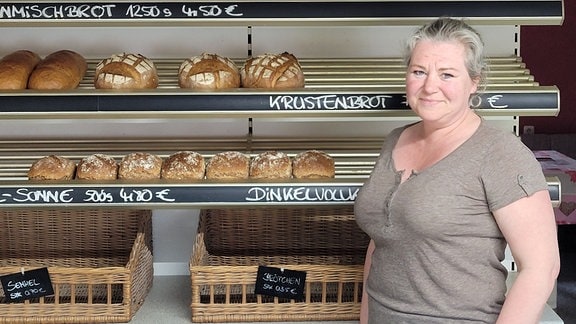 Daniele Wallwitz steht in der Landbäckerei Schulle in Hohenwarthe neben einer Auslage mit Broten.