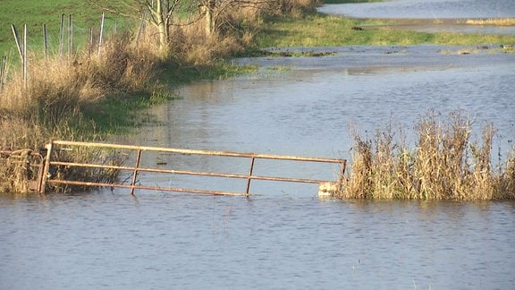Ein Zaun auf einem Feld steht unter Wasser