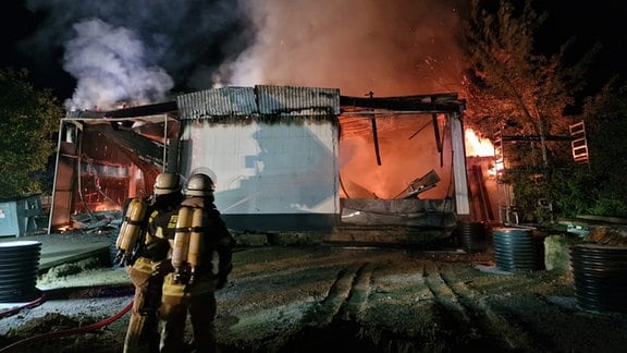 Feuerwehr bei Löscharbeiten an einer brennenden Lagerhalle