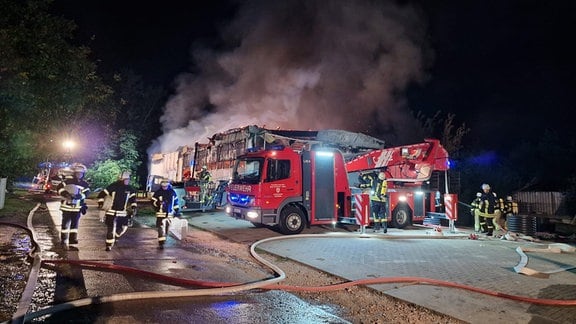 Feuerwehr bei Löscharbeiten an einer brennenden Lagerhalle