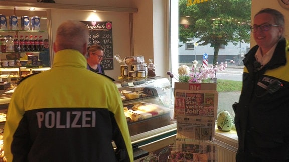 Die Polizisten Susanne Scharf und Jens Ruhnke in einer Bäckerei.