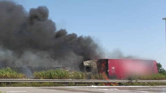 Trümmerteile und eine schwarze Rachsäule brennender LKW auf der A2