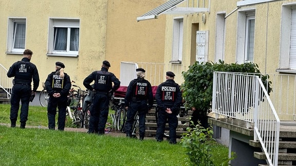 Polizisten stehen an einem Einsatzort, der möglichwerweise im Zusammenhang mit der Attacke in Wolmirstedt steht. 