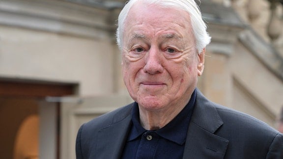 Der Autor, Filme- und Fernsehmacher Alexander Kluge: Ein alter Mann mit weißem Haar und dunkler Kleidung lächelt in die Kamera.