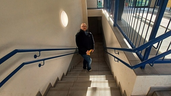 Patrick Wohlmacher steht auf einer Treppe in der Grundschule Silstedt.