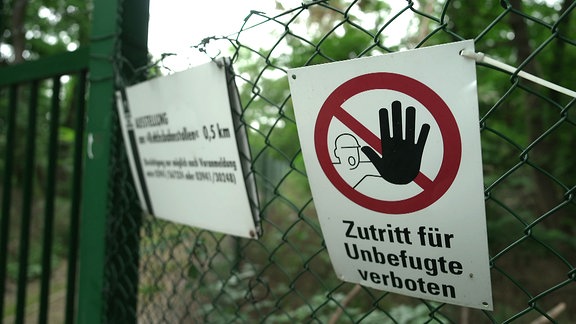 Zutritt Verboten-Schild an einem grünen Tor