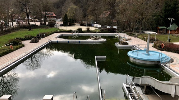 Das Freibad Rübeland samt Wasserrutsche und Pilz an einem bewölkten Tag.