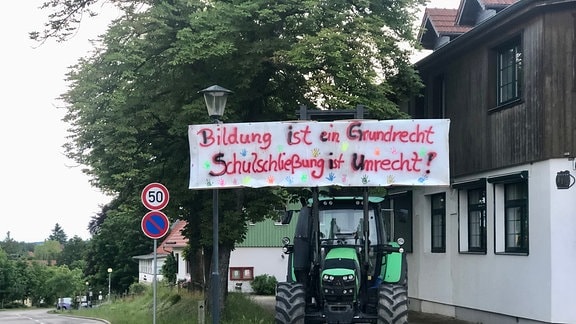 Ein Plakat hängt an einem Traktor.