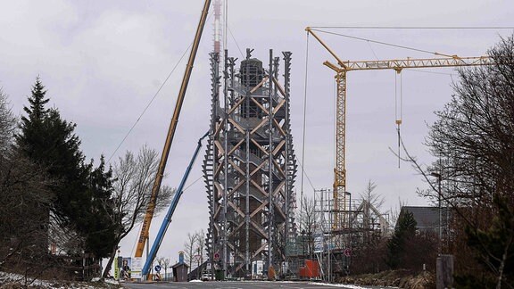 Krane stehen auf der Baustelle des Aussichtsturms Harzturm