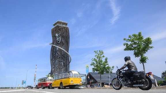 Oldtimer-Reisebusse stehen vor dem Harzturm.